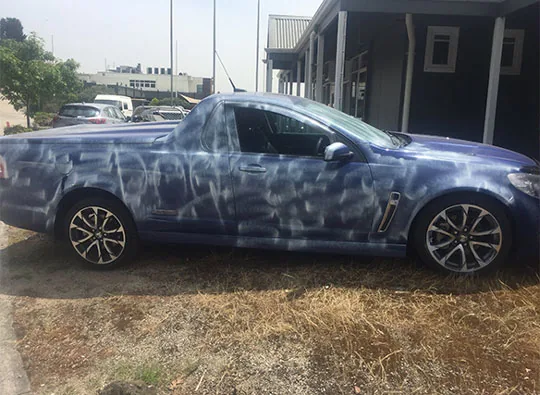 Blue Holden ute showing industrial fallout across the panels